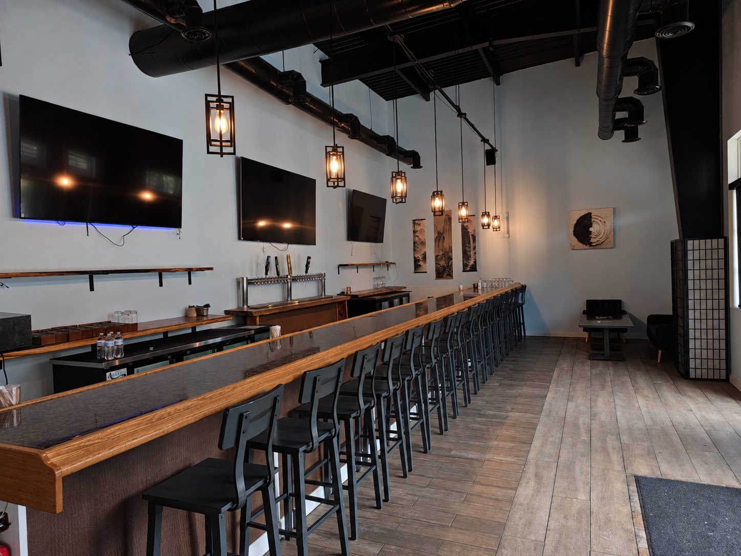 The long oak bar at Osaka Express with ten taps and lantern pendants