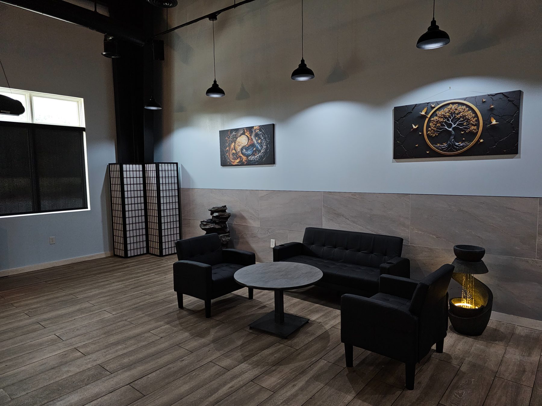 Lounge seating with a lit water fountain and koi yin-yang canvas at Osaka Express