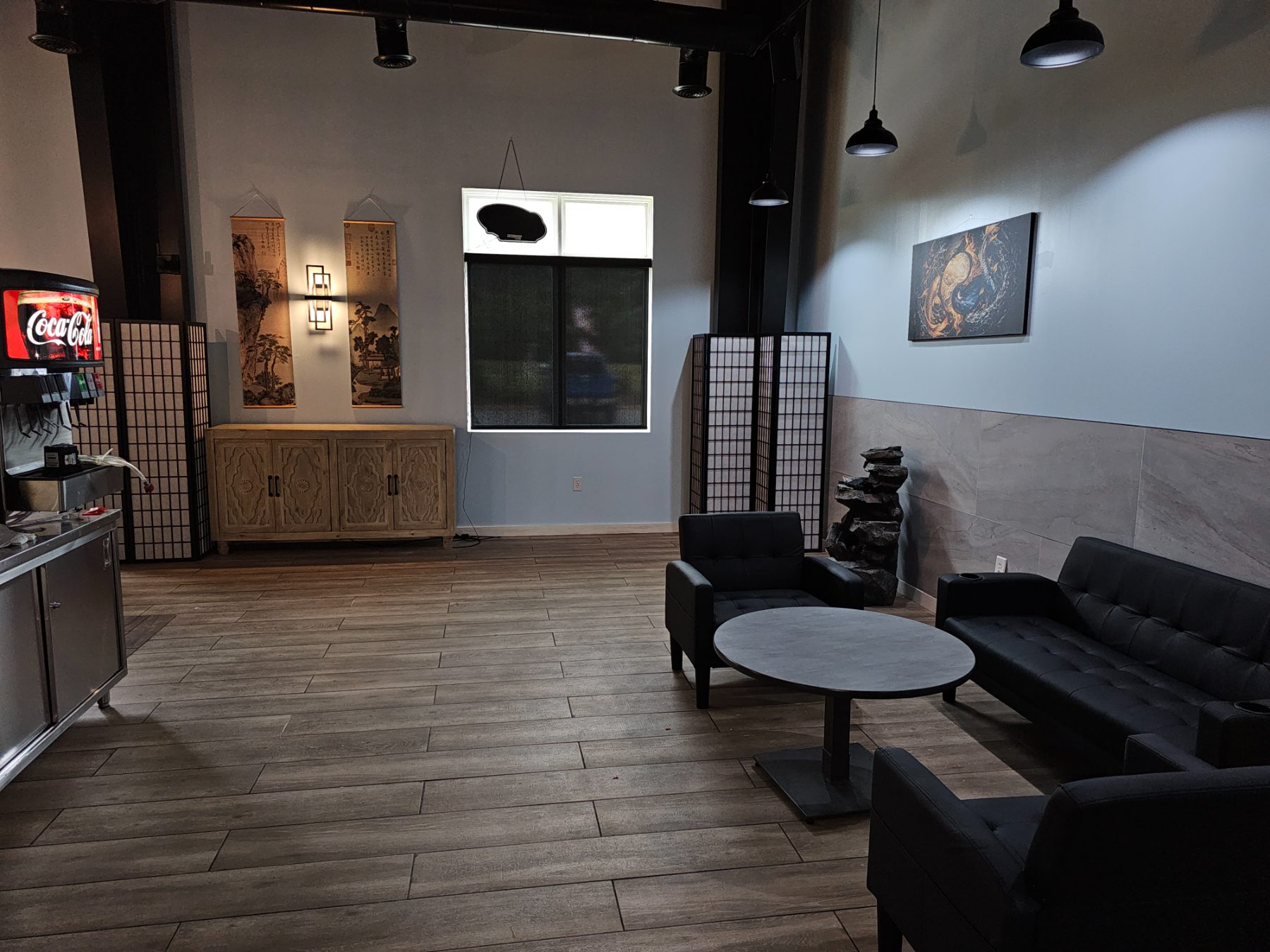 The lounge corner at Osaka Express with hanging scrolls and a carved cabinet